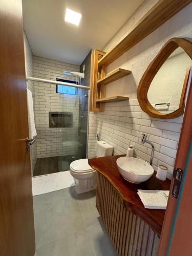 a bathroom with a sink and a toilet and a mirror at Seaesta Milagres in São Miguel dos Milagres