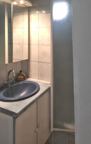 une salle de bain avec un lavabo et un miroir dans l'établissement Charmant appartement avec piscine partagée à Agde, au Cap d'Agde