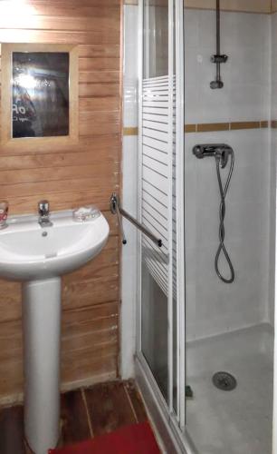 a bathroom with a sink and a shower at Bungalow charmant au Robert avec piscine partagée et jardin in Le Robert