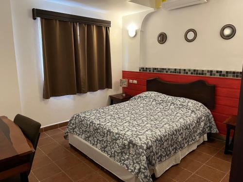 a bedroom with a bed and a window at Easy Inn Hotel in Belize City