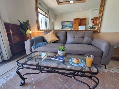 a living room with a couch and a glass table at Seafront Bedroom with stunning views, balcony and en-suite in Marsaskala