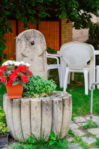 a garden with a table and chairs and flowers at Mediterrán Vendégház in Kecskemét