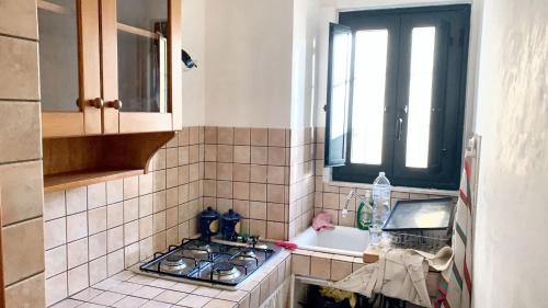a kitchen with a stove and a sink and a window at Comfortable house in Noto with air conditioning on 30 m² in Noto