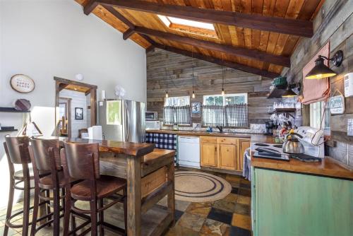 a kitchen with wooden cabinets and a bar with stools at Cabin at the Forest Edge in Packwood