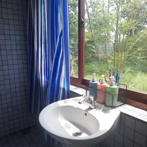 a white sink in a bathroom with a window at Lux Home Phước Hải 2 in Hội Mỹ