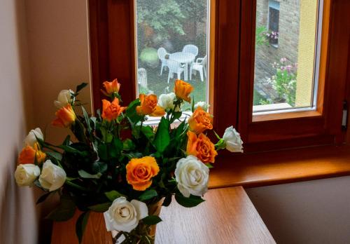 a vase of flowers sitting on a window sill at Mediterrán Vendégház in Kecskemét