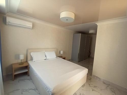 una camera da letto con un letto bianco con due cuscini di Apartament Milenium a Pomorie