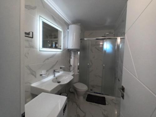 un bagno con lavandino, WC e doccia di Apartament Milenium a Pomorie