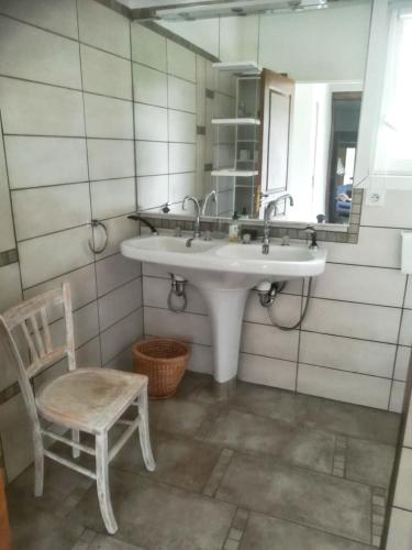 La salle de bains est pourvue d'un lavabo, d'une chaise et d'un miroir. dans l'établissement Maison familiale spacieuse à Lacam-d'Ourcet avec jardin 115 m², à Lacam-dʼOurcet