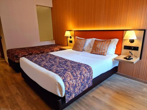 a bedroom with two beds in a hotel room at Hotel 3K Porto Aeroporto in Maia