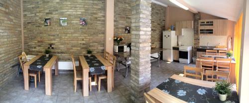 a kitchen and dining room with wooden tables and chairs at Mediterrán Vendégház in Kecskemét