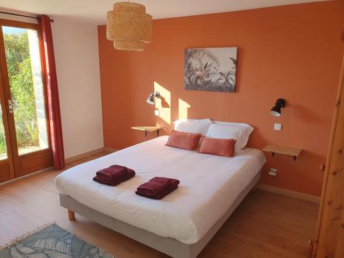 a bedroom with a large bed with two pillows on it at Spacieux et charmant T3 entre campagne et montagne in Jarrie
