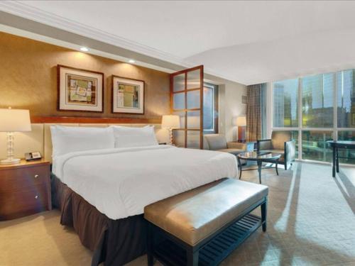 une chambre avec un grand lit et un salon dans l'établissement Ultimate Vegas Trip with Sphere View, Pool and Gym, à Las Vegas