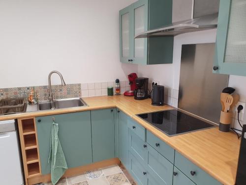 a kitchen with blue cabinets and a sink at Spacieux et charmant T3 entre campagne et montagne in Jarrie