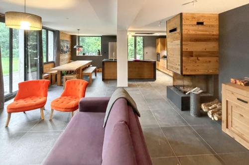 - un salon avec un canapé et des fauteuils orange dans l'établissement Chalet magnifique à Valloire avec vue sur montagne., à Valloire