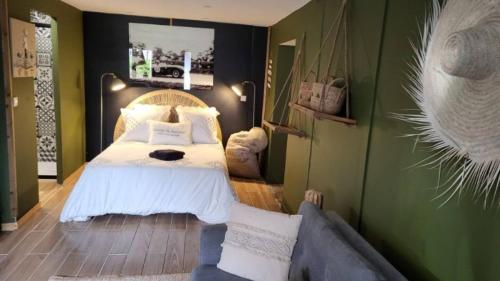 a bedroom with a bed and a couch at Logement proche de la mer in Bernières-sur-Mer