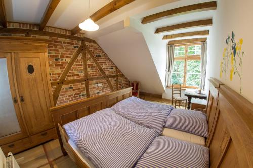 a bedroom with a bed and a brick wall at Landhaus Schulze Osthoff in Warendorf