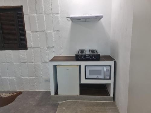 a counter with a microwave and a stove on it at Sitio Azeite com Pimenta in Itabirito