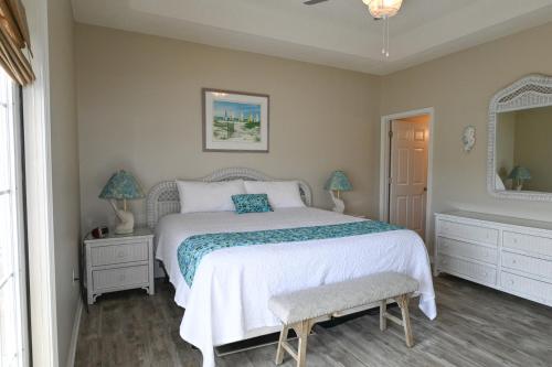 Un dormitorio con una cama blanca y un espejo. en Welcome to Sandpiper Cove Unit 4234 Your Destin Beach Getaway, en Destin