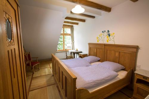 ein Schlafzimmer mit einem Holzbett mit lila Kissen in der Unterkunft Landhaus Schulze Osthoff in Warendorf