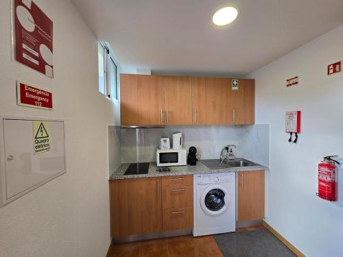 a kitchen with a washing machine and a sink at Autonomia House III in Câmara de Lobos