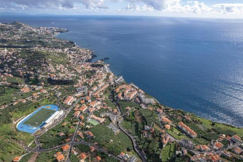 an aerial view of a city next to the ocean at Autonomia House III in Câmara de Lobos