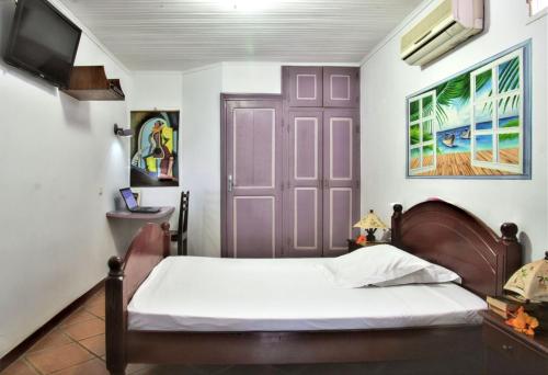 a bedroom with a bed and a purple door at Charming Studio in Foulpointe, Sea View and Garden, 30 m² in Foulpointe