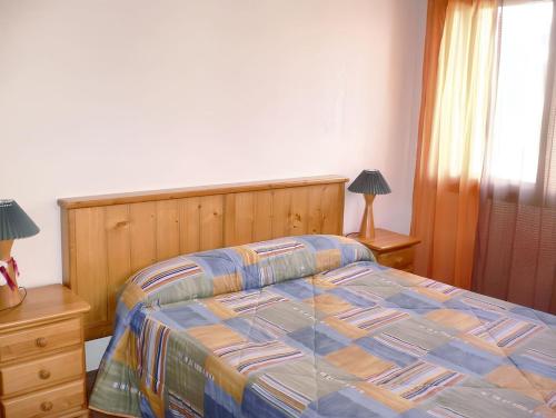 a bedroom with a bed and two lamps and a window at Comfortable Apartment with Mountain View in Laspaúles in Laspaúles