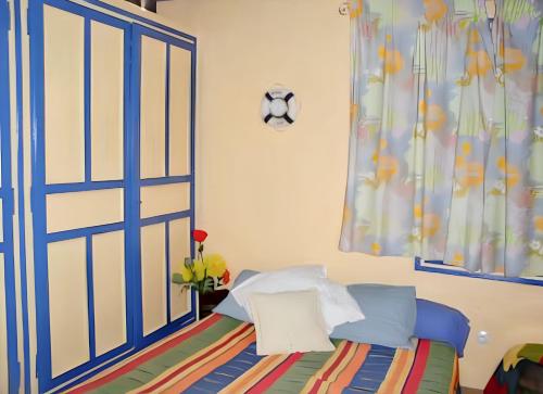 sypialnia z łóżkiem z niebieskimi drzwiami w obiekcie Maison accueillante à Calcatoggio avec jardin clôturé. w mieście Calcatoggio