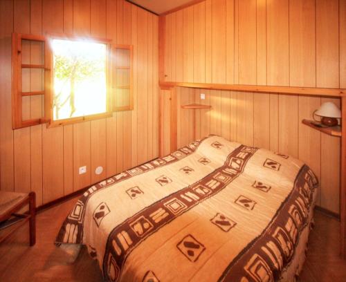 a large bed in a room with a window at Bungalow confortable à Santa-Lucia-di-Moriani 38 m² jardin spacieux in Santa-Lucia-di-Moriani