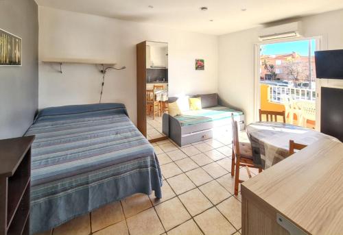une chambre avec un lit, un bureau et une fenêtre dans l'établissement Studio confort à Hyères - 20 m² avec barbecue et terrasse, à Hyères
