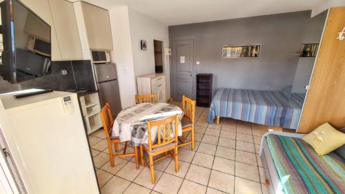 une cuisine avec une table et des chaises dans une pièce dans l'établissement Studio confort à Hyères - 20 m² avec barbecue et terrasse, à Hyères