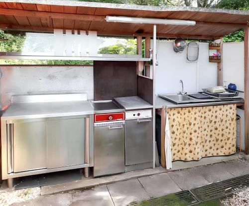 une cuisine extérieure avec une cuisinière et un évier dans l'établissement Chalet de charme à Molinot + Piscine privée, à Molinot