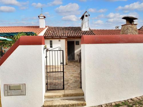 a gate to a house with a church at Charming House in Beirã with Garden in Beirã