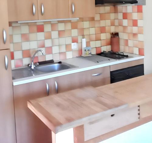 une cuisine avec un évier et une cuisinière dans l'établissement Appartement confortable à Hyères avec terrasse, à Hyères