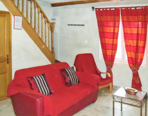 a red couch and a chair in a living room at Appartement spacieux à Monteux avec piscine partagée in Monteux
