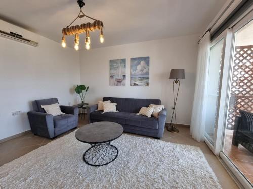 a living room with a blue couch and a table at North Cyprus Thalassa beach resort in Paralimni