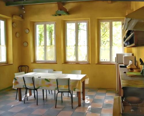 une cuisine avec une table et des chaises dans une pièce dans l'établissement Maison familiale spacieuse à Saint-Claude, vue sur la rivière, à Saint-Claude