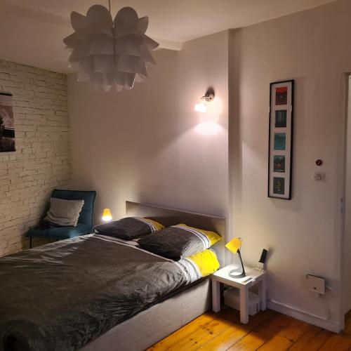 une chambre avec un lit et une chaise dans l'établissement L' effet mer, à Dunkerque