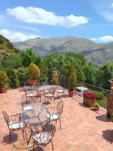 a patio with tables and chairs with mountains in the background at Cozy Apartment in Ardanué with View in Ardanué
