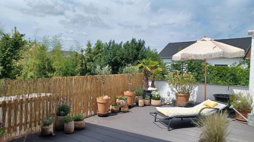 a patio with potted plants and an umbrella at Ruhige Ferienwohnung Beletage in Neuwied