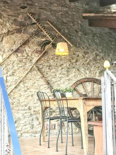 a dining room table with chairs and a stone wall at Cozy Apartment in Ardanué with View in Ardanué