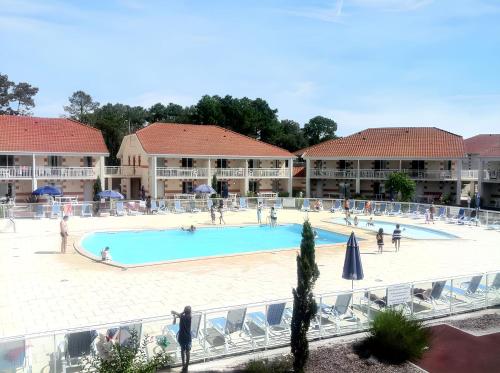 a large swimming pool in front of a resort at Appartement convivial Le Verdon 35 m² piscine partagée in Le Verdon-sur-Mer