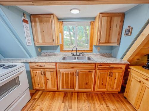 una cucina con mobili in legno e un lavello di Lake Life, Hocking Hills, Hot Tub, Fireplace, Pond a Rockbridge