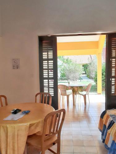 a room with a table and chairs and a dining room at Maison cosy Les Anses d'Arlet + Jardin in Les Anses-dʼArlets