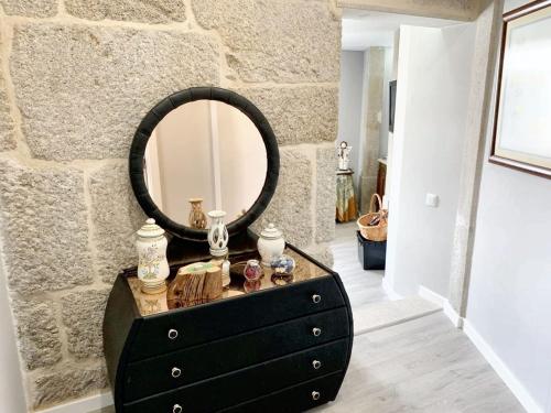 a black dresser with a mirror on top of it at Cozy house in Castelo Branco, 60 m², city view balcony in Castelo Branco