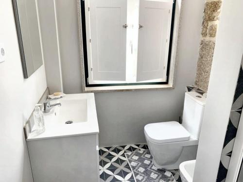a bathroom with a sink and a toilet and a mirror at Cozy house in Castelo Branco, 60 m², city view balcony in Castelo Branco