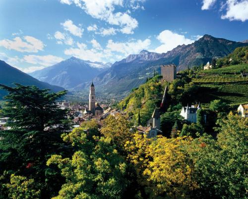 a town on a hill with mountains in the background at Hotel Schönbrunn in Merano