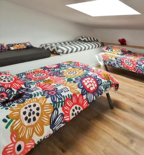 3 lits dans une pièce ornée de fleurs dans l'établissement Villa avec Piscine - Vue Mer - Plougonvelin, à Plougonvelin