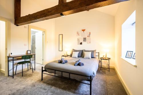 una camera da letto con un letto e una scrivania di Sleeps 28 I Luxurious 3-Barn Retreat I 3 Hot Tubs I Games room a Preesgreen